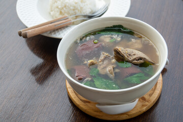 Pork blood tofu soup with gourd leaves,Clear soup asian style food mixed minced pork balls,
Pork blood cubes and liver in with bowl,Healthy and Rich in iron and protein