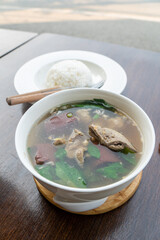 Pork blood tofu soup with gourd leaves,Clear soup asian style food mixed minced pork balls,
Pork blood cubes and liver in with bowl,Healthy and Rich in iron and protein