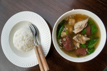 Pork blood tofu soup with gourd leaves,Clear soup asian style food mixed minced pork balls,
Pork blood cubes and liver in with bowl,Healthy and Rich in iron and protein
