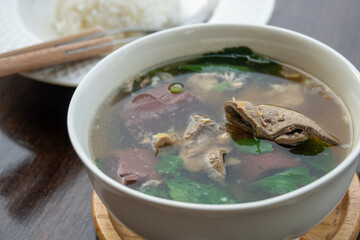 Pork blood tofu soup with gourd leaves,Clear soup asian style food mixed minced pork balls,
Pork blood cubes and liver in with bowl,Healthy and Rich in iron and protein