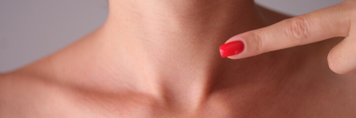 Woman manually checks thyroid gland in neck closeup