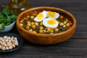 wooden bowl with chickpeas with spinach and hard-boiled egg