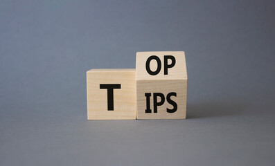 Top Tips symbol. Turned wooden cubes with words Top Tips. Beautiful grey background. Business and Top Tips concept. Copy space