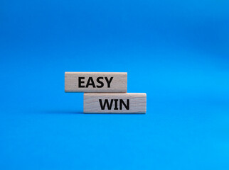 Obraz premium Easy win symbol. Wooden blocks with words 'Easy win'. Beautiful blue background. Business and 'Easy win' concept. Copy space.