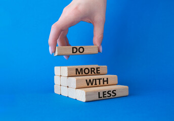 Do more with less symbol. Concept words Do more with less on wooden blocks. Businessman hand....