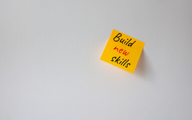 Build New skills symbol. Concept word Build New skills on orange steaky note. Beautiful white background. Business and Build New skills concept. Copy space