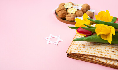 Passover Greeting Card with Matzah, Nuts and Spring Flowers on Pink Background.