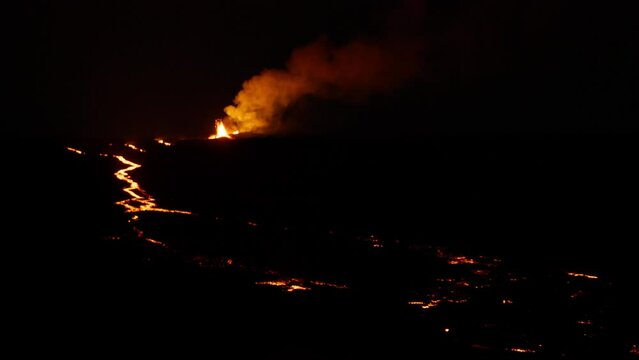 Epic view of lava fountain shooting up into air from Hawaii Mauna Loa volcano eruption of 2022. Red orange yellow glowing hot lava and magma erupting out of volcano at night. Dramatic shot RED camera