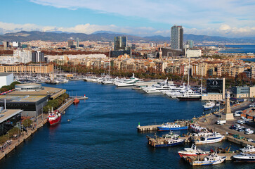 Fototapeta na wymiar Barcelona, Spain-January 02,2016:Picturesque aerial landscape view of Port Vell with moored yachts and ships in Barcelona. Downtown of Barcelona in the background. Travel and tourism concept
