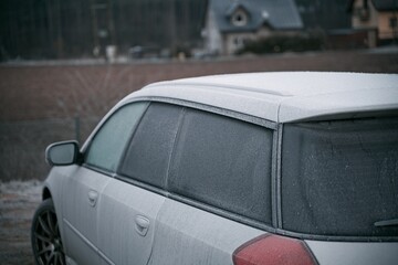 car is covered with frost. cold morning with a vehicle parked outside during night