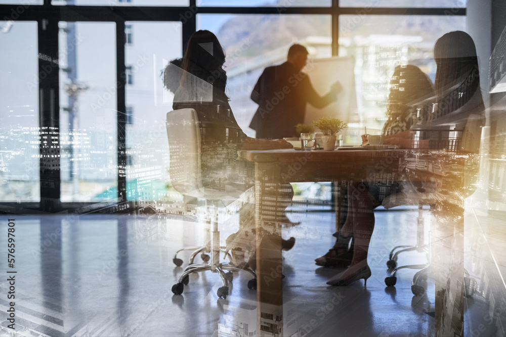 Wall mural Building their empire from the ground up. Shot of a team of brainstorming businesspeople double exposed with an image of a city.