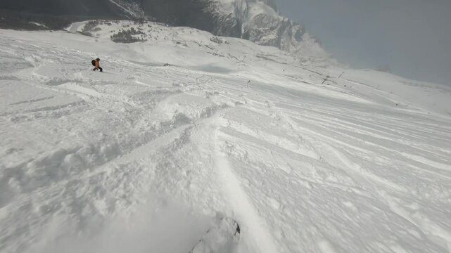Snowboarding on puffy snow in big mountains white snow clear weather sun
