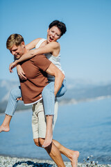 Middle aged couple in love having fun piggybacking. Mix national relationship. 