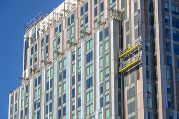 Construction workers inspecting / installing cladding on an apartment building in London, England