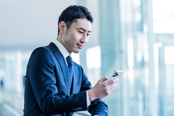 携帯を持つ日本人ビジネスマン