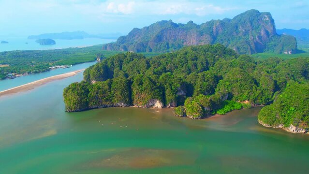 Limestone mountains at the estuary in Thailand are covered with lush green forests, interspersed with large patches of mangrove forests, as seen from a drone. nature and ecosystem concept. 4K UHD
