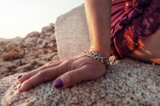 womans&acirc;&euro;&trade; hand and hip on rock in joshua tree