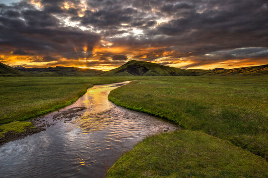 Landmannalauger Highlands stream through mossy field and sun rays, Iceland