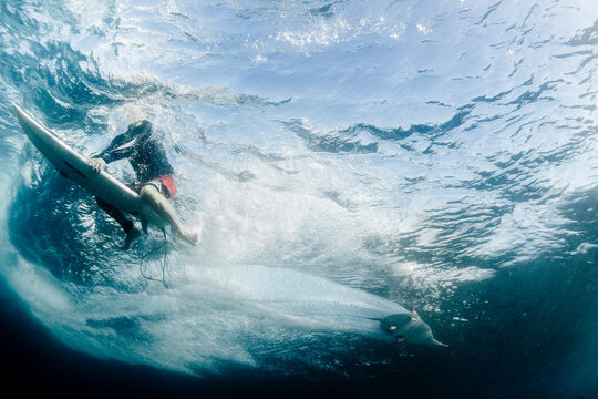 Underwater point of view of a man surfing on a surfboard