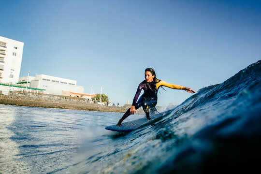 A surfer girl rides her longboard during a before sunset session