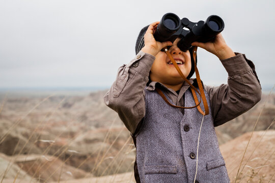 Boy wearing explorer costume holding binoculars