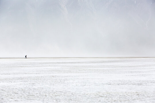 Lone hiker walking through dust storm, Kluane National Park, Yukon, Canada