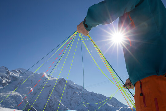 Pilot checking paragliders lines to make sure they are undamaged and aligned, Chamonix, Haute-Savoie, France