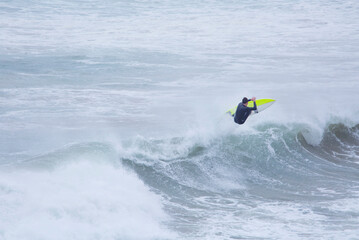 Single Surfer riding a wave in Autumn storm,Cornwall,UK