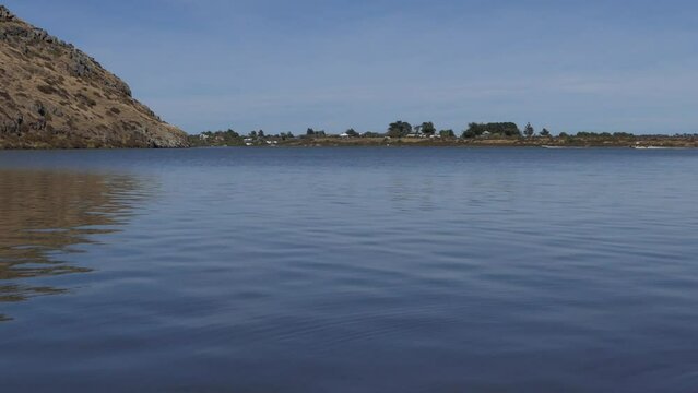 Patterns in calm lake water contrast with speed of power boats in distance - Lake Forsyth (New Zealand)