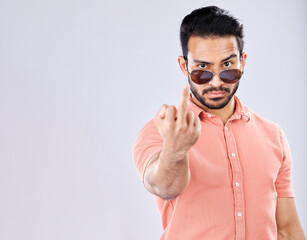 Cool, rude and portrait of an Asian man with a middle finger isolated on a grey studio background. Mockup, angry and mean guy with an offensive hand gesture, expression and space on a backdrop