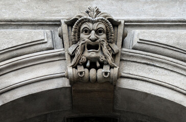 Stone theatrical Mask or Mascaron - decor element on the wall of the Theater building. Tragic mask...