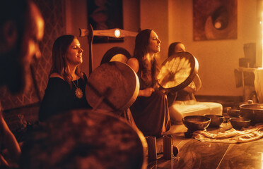 beautiful women playng on tibetan bowl and shaman drum, ceremonial space.
