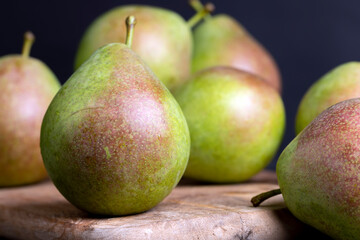 Whole ripe green pears on the board