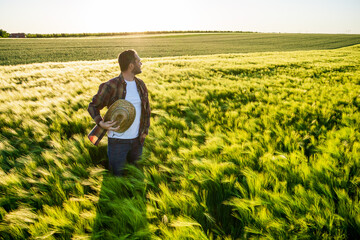 Farmer is cultivating barley. He is satisfied because of good season.