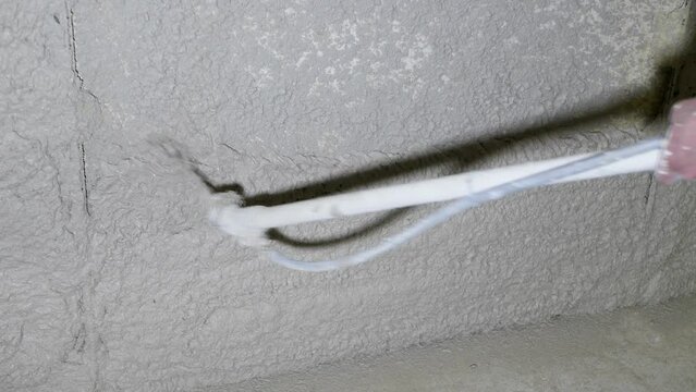 The process of applying plaster to walls inside a building by machine.