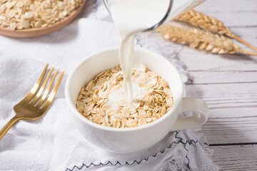 A cup of lean oatmeal milk  porridge on wooden table.healthy breakfast