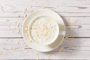 A cup of lean oatmeal milk  porridge on wooden table.healthy breakfast