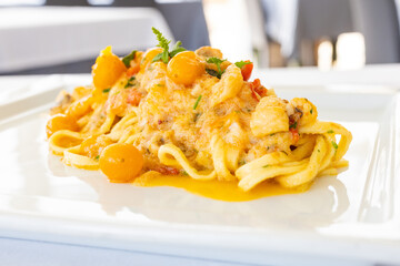 Piatto di scialatielli napoletani con pomodori datterini gialli, rana pescatrice e menta serviti...