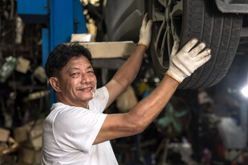 Smiling Asian car Mechanic man working in auto repair shop