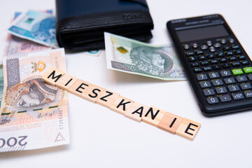inscription mieszkanie which means apartment next to polish money. concept showing cheap loans for...