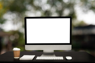Computer Monitor, Keyboard, coffee cup and Mouse with Blank  is on the work table at the sky mountain river and trees front view background. in morning light .