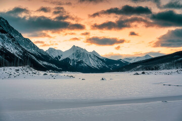 Obraz na płótnie Canvas Sunrise over Medicine Lake with rocky mountains and frozen lake in Jasper national park