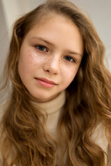Naklejka premium Portrait of serious girl with golden star freckles and long hair looking at camera. Soft focus.