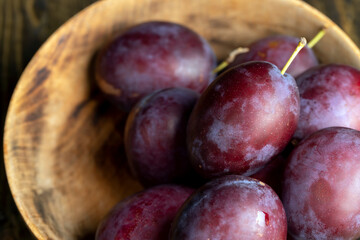 Ripe plums of dark color on the table