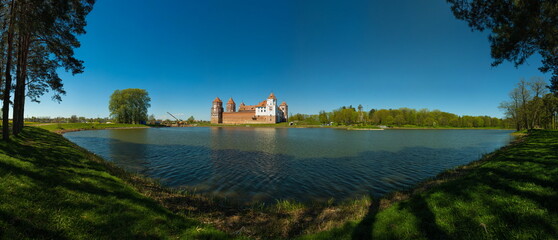 Castle complex on the lake shore against the blue sky