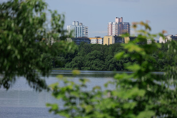 Fototapeta premium Buildings and houses standing on the shore of a lake, river or sea. Cityscape and urban scene.