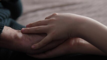close-up the child's hand strokes and hugs the wrinkled hands of the grandfather, care for the guardianship of pensioners, family values, support for loved ones.