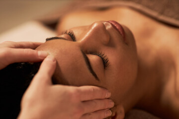 Young woman receiving face massage to get glowing and firm complexion