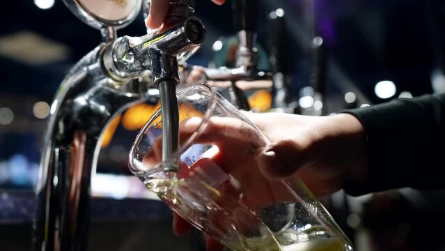 bartender pouring beer from tap in bar, closeup of hands and glass, enjoy fresh ale or lager