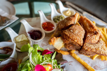 Eisbein with braised cabbage, salad and Yummy french fries with set of souces in bowl. Traditional Oktoberfest smoked pork knuckle eisbein, sauce and baked spices potato. German festival food concept.